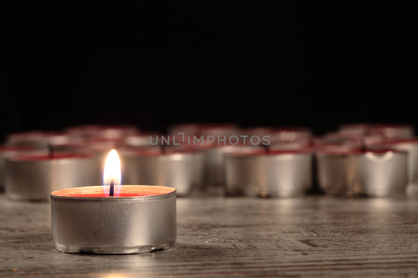 red candle on a wooden floor