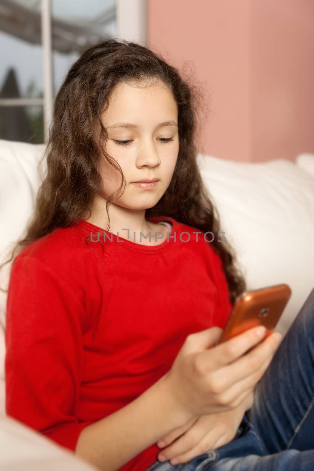 An image of a young girl with a mobile phone