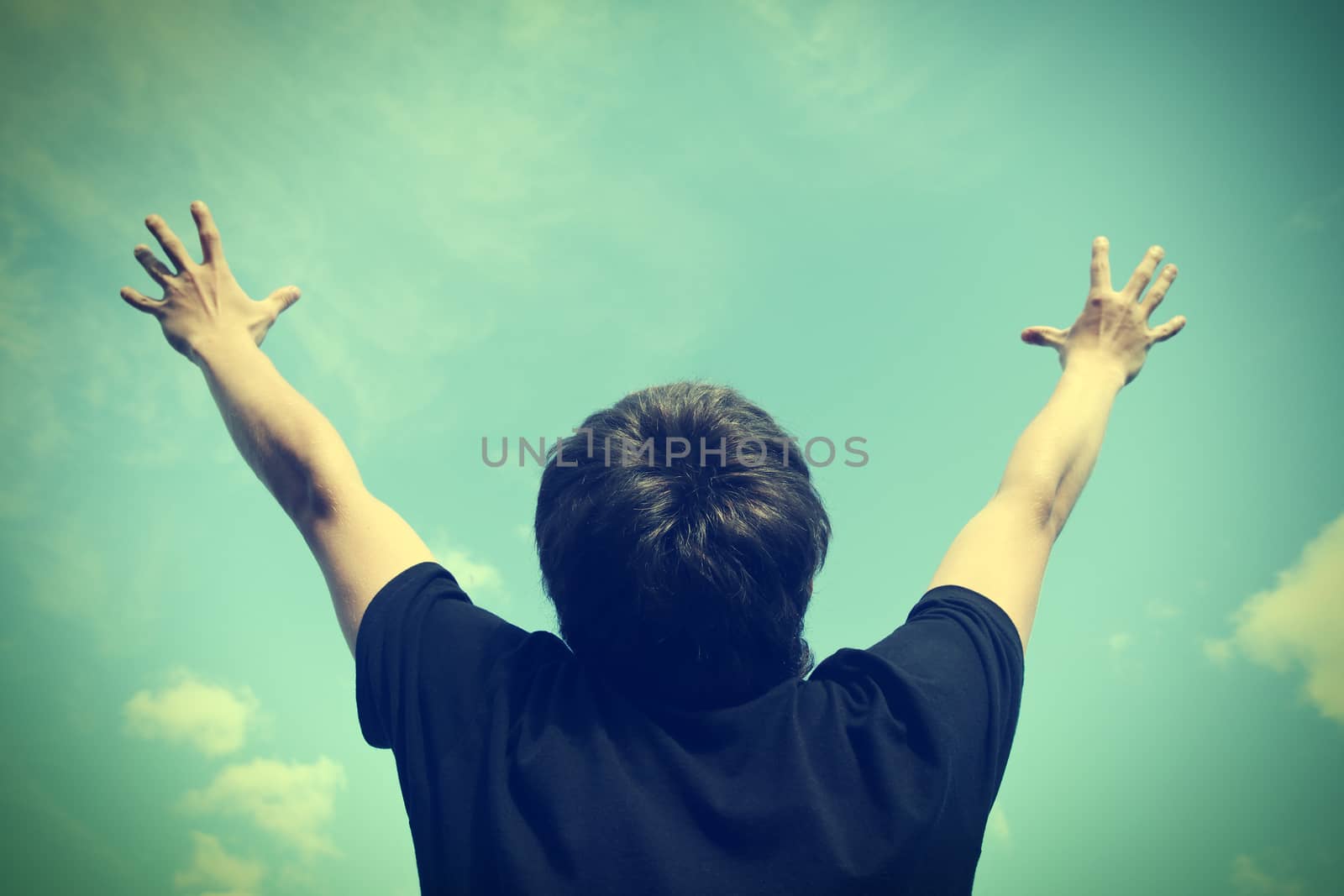 Toned photo of Happy Teenager with Hands Up on the Sky background