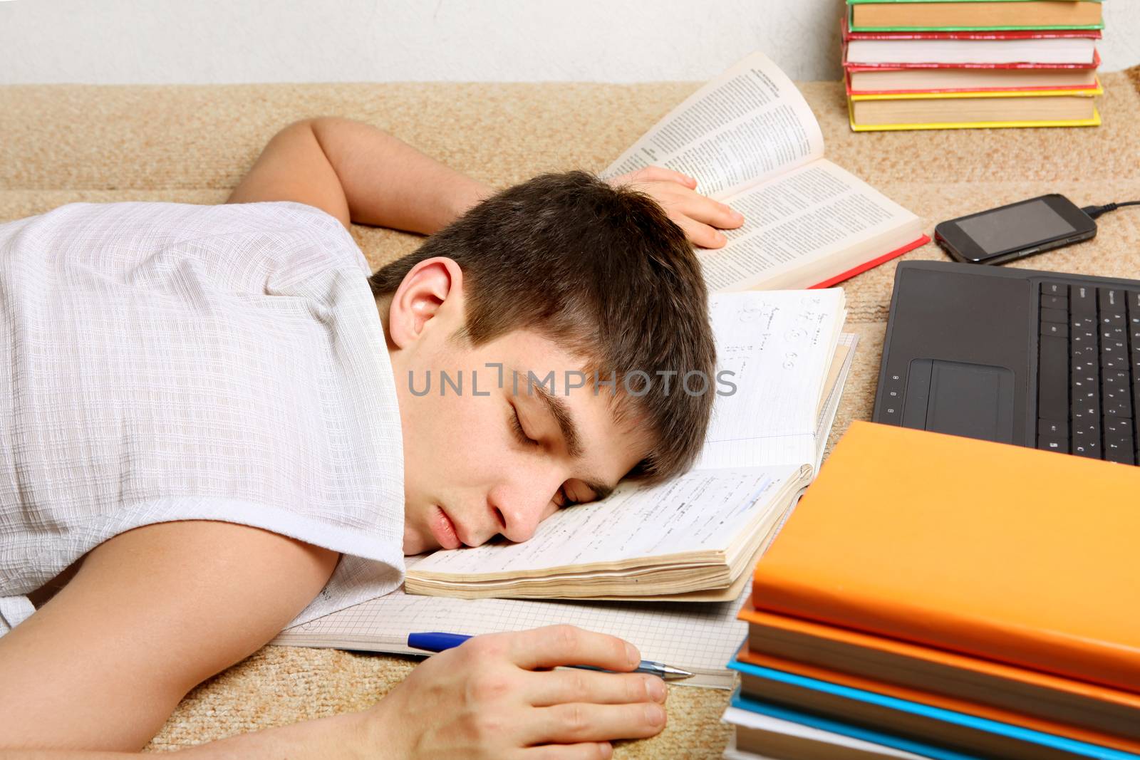 Tired Teenager sleeping on the Books at the Home