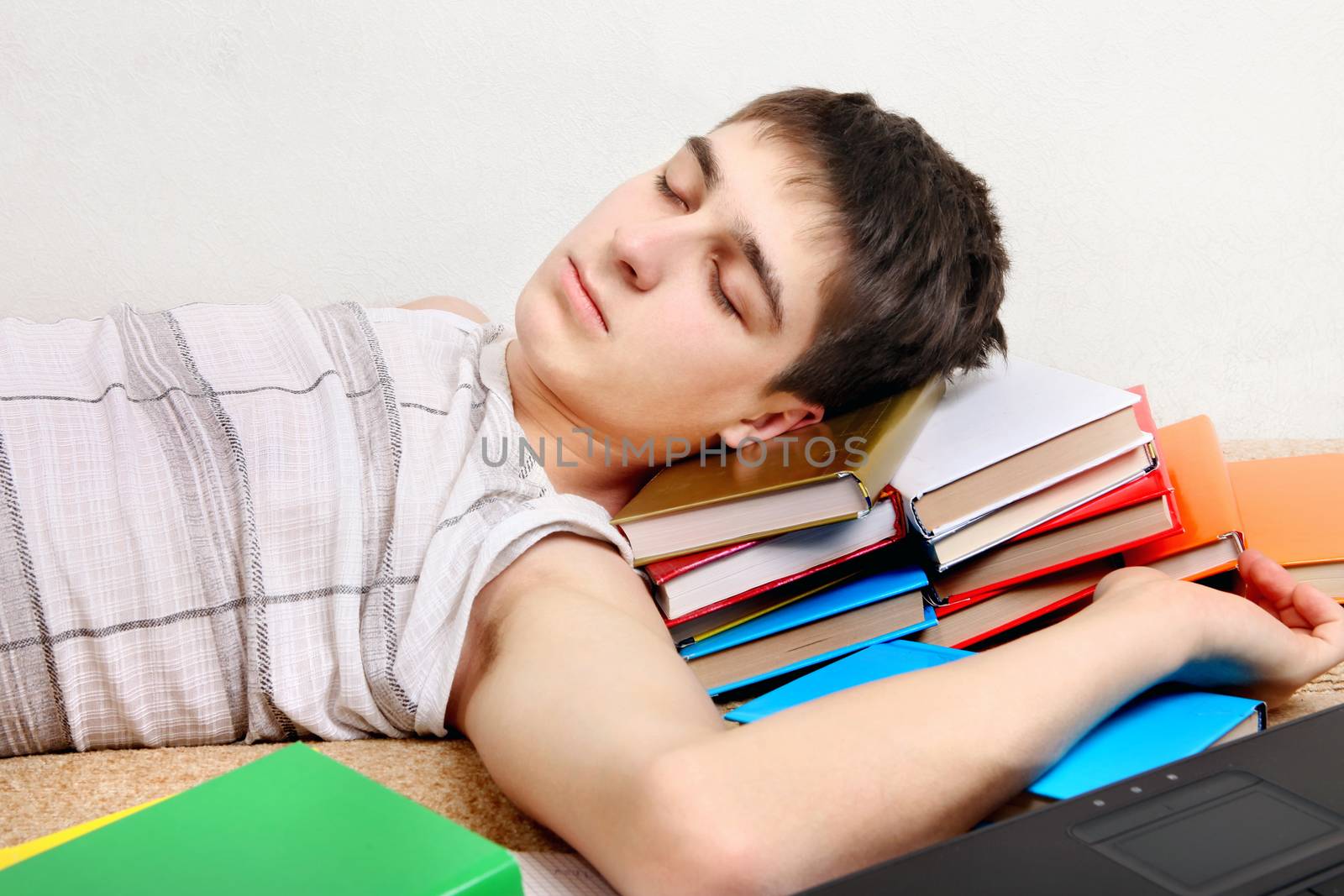 Tired Teenager sleeping on the Books at the Home