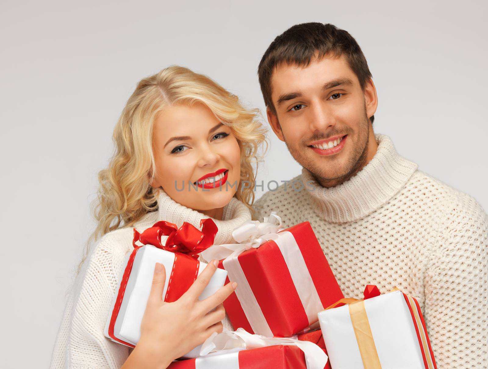 family couple in a sweaters with gift boxes by dolgachov