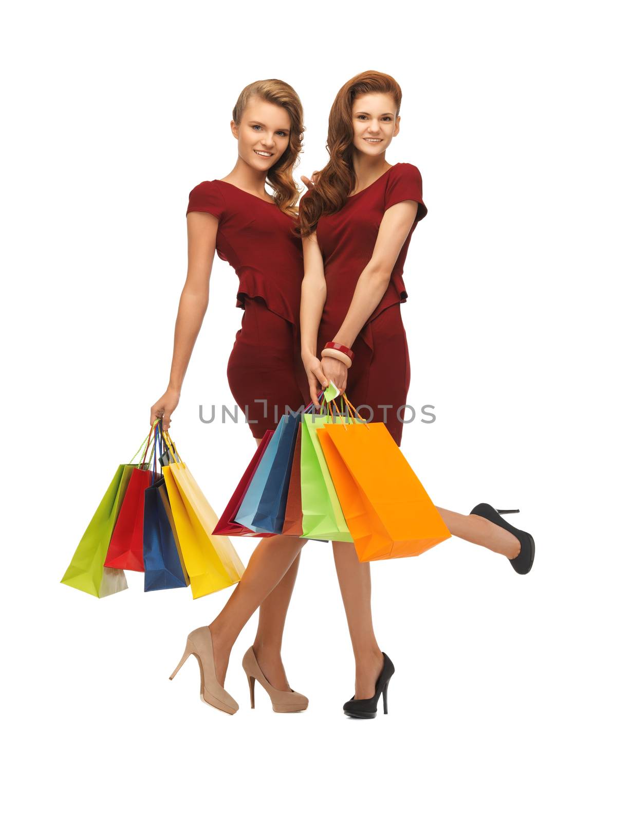 teenage girls in red dresses with shopping bags by dolgachov