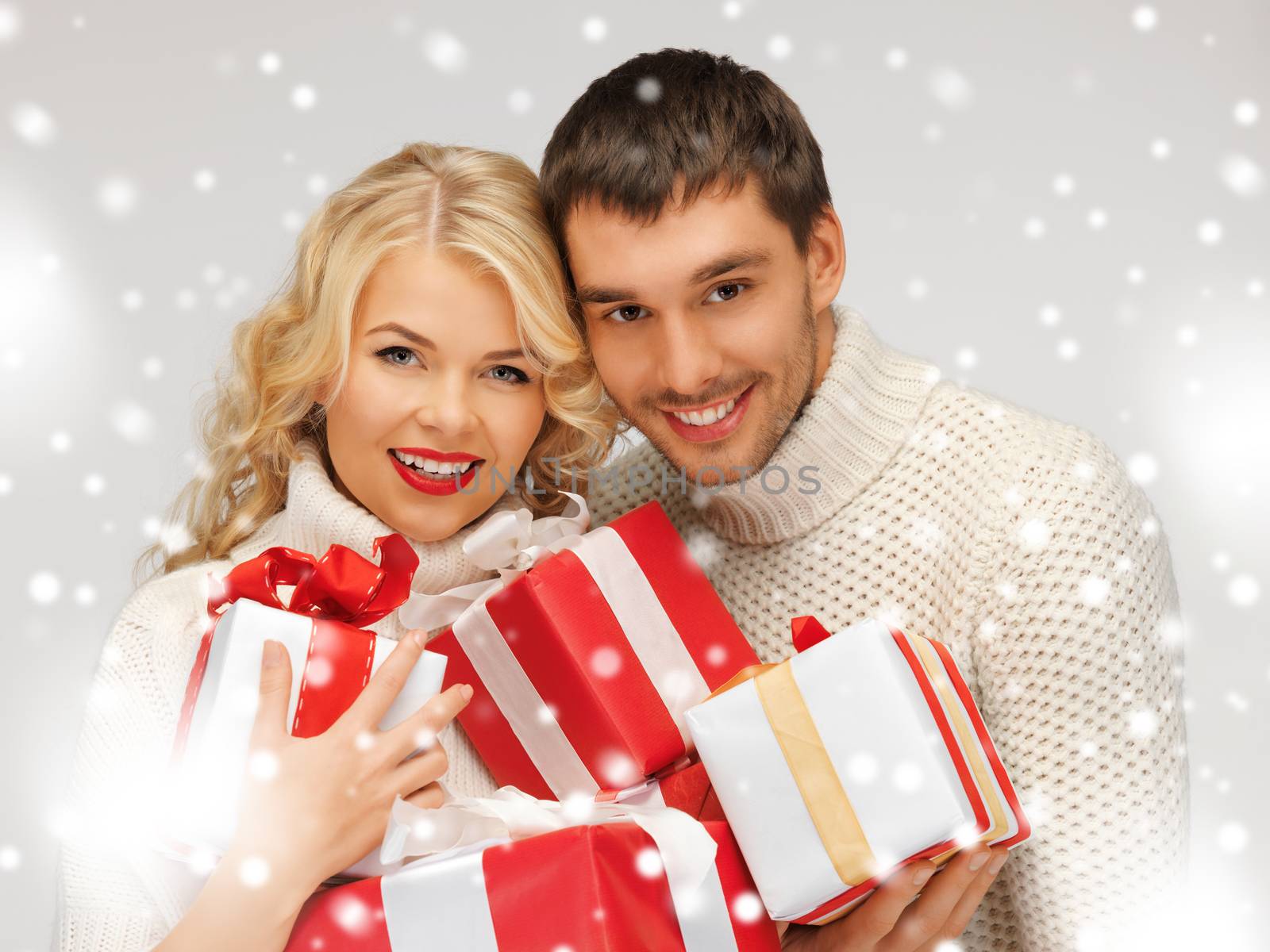 picture of romantic couple in a sweaters with gift boxes