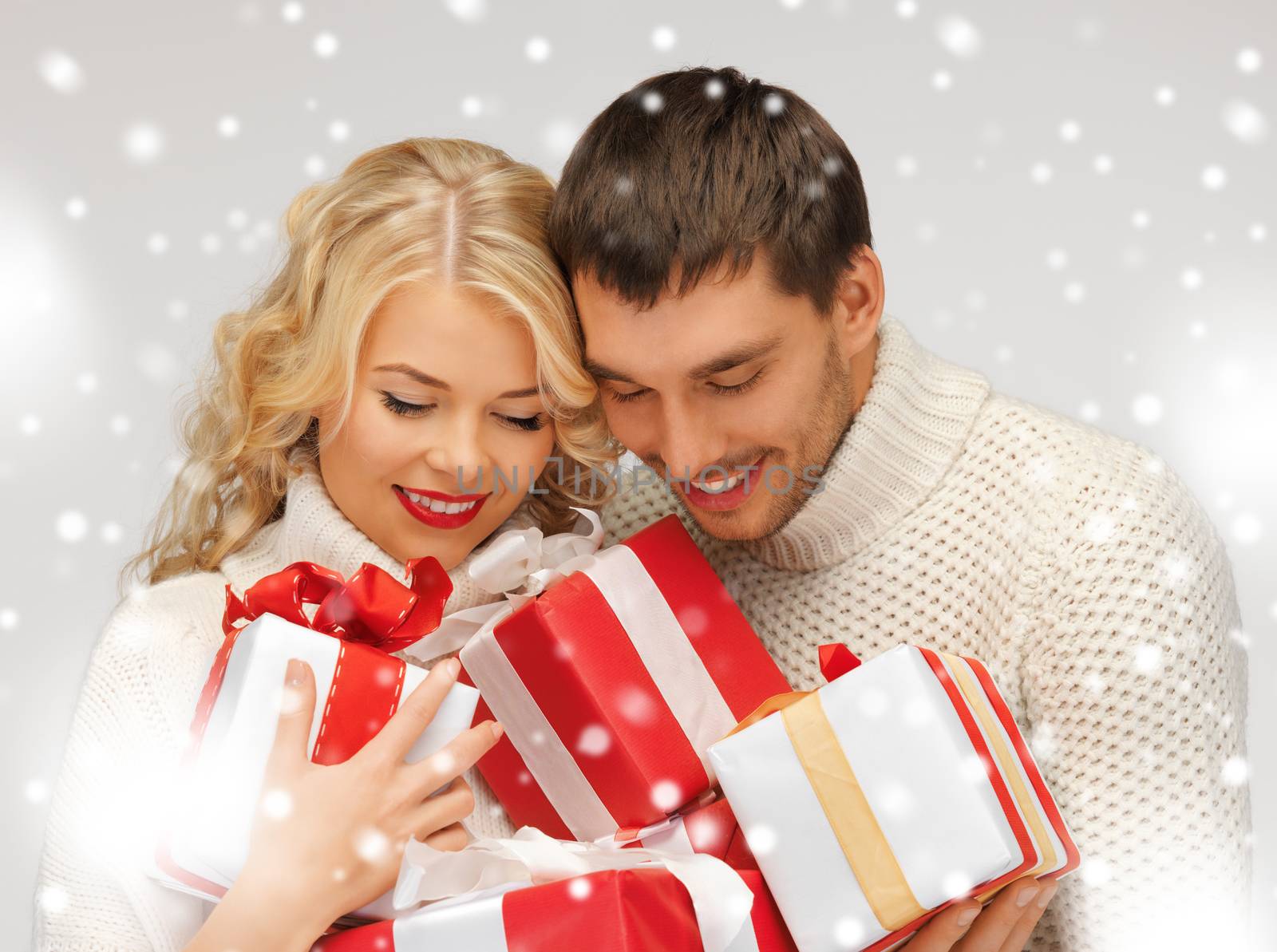 picture of romantic couple in a sweaters with gift boxes