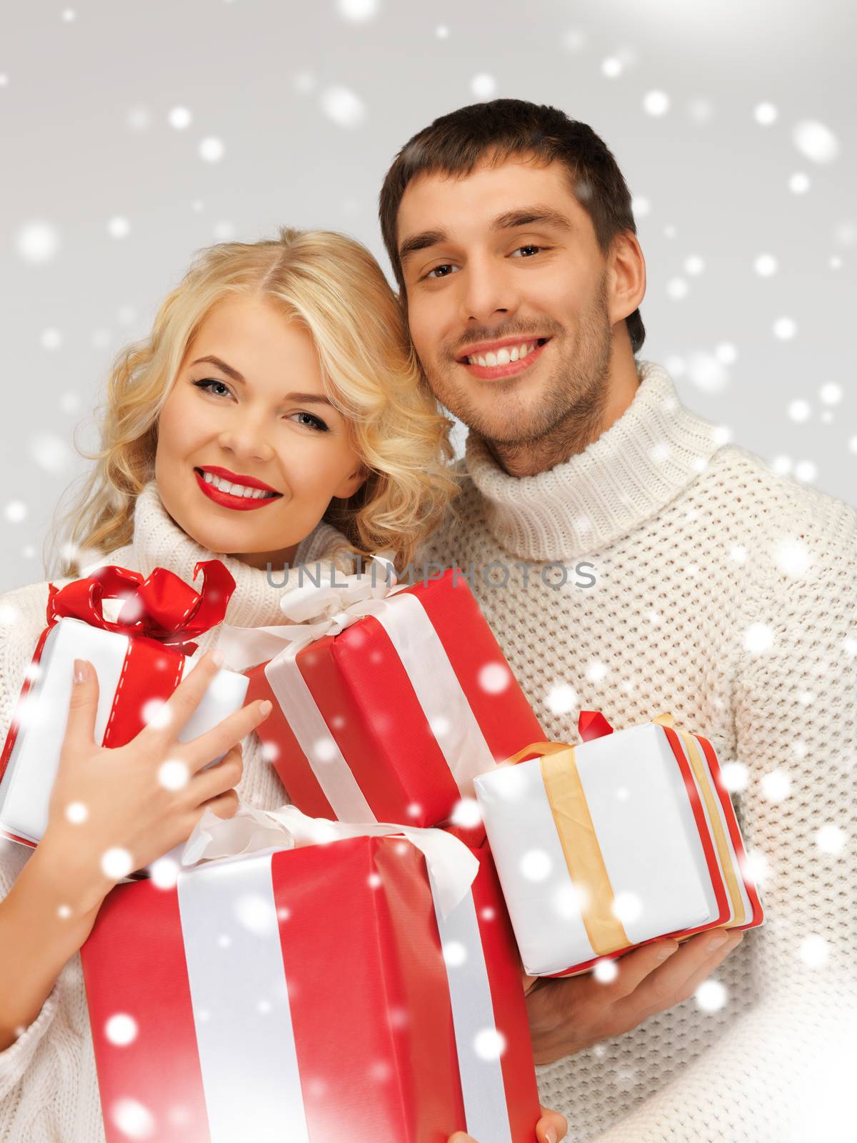 picture of family couple in a sweaters with gift boxes