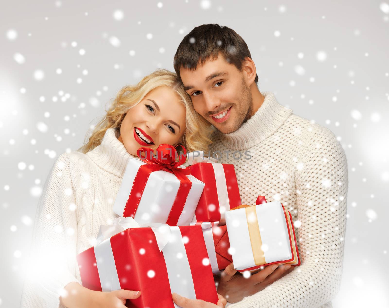 romantic couple in a sweaters with gift boxes by dolgachov