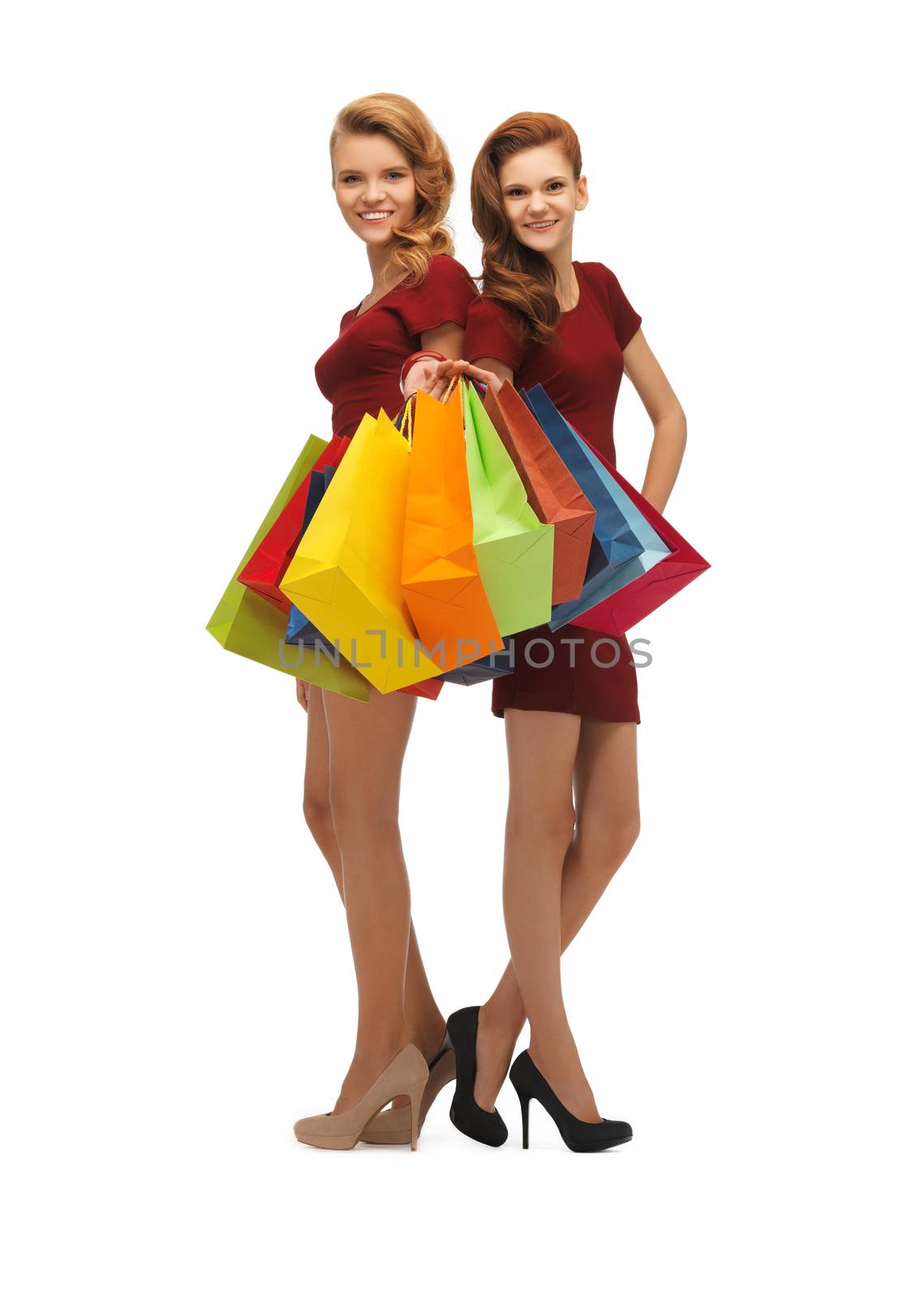 teenage girls in red dresses with shopping bags by dolgachov