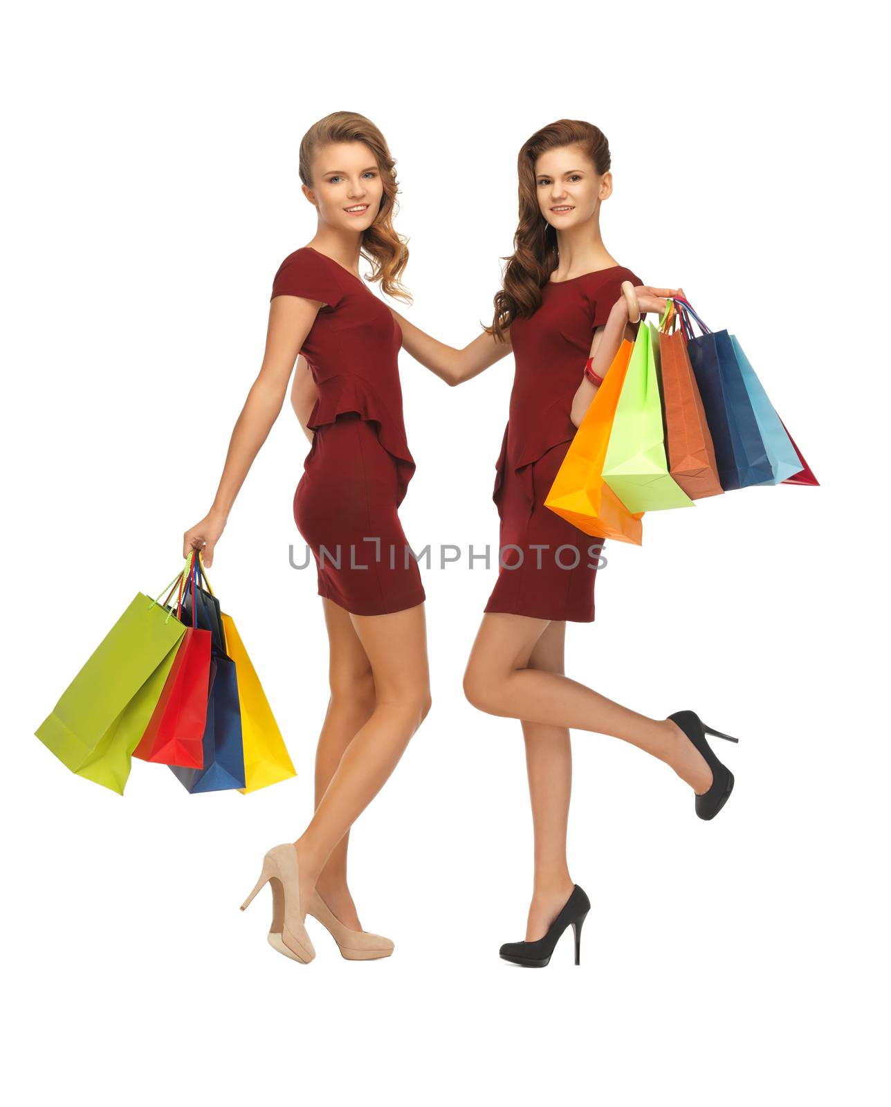 teenage girls in red dresses with shopping bags by dolgachov