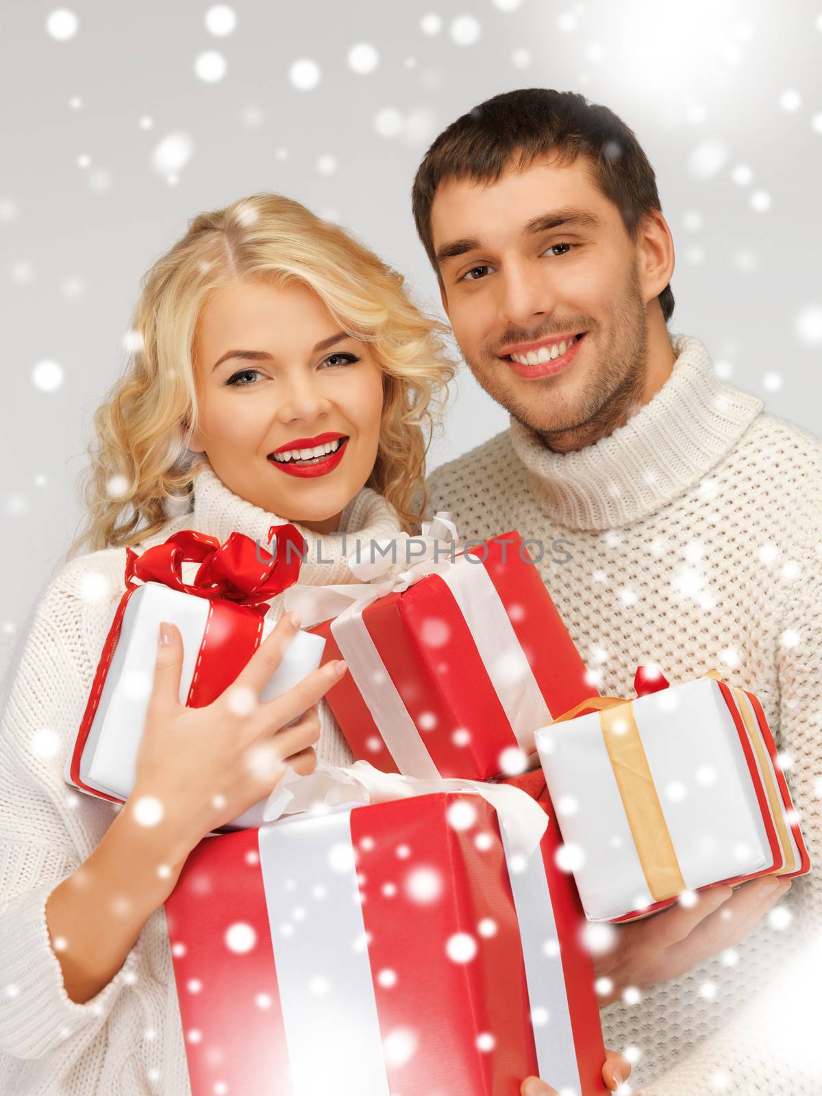 picture of family couple in a sweaters with gift boxes