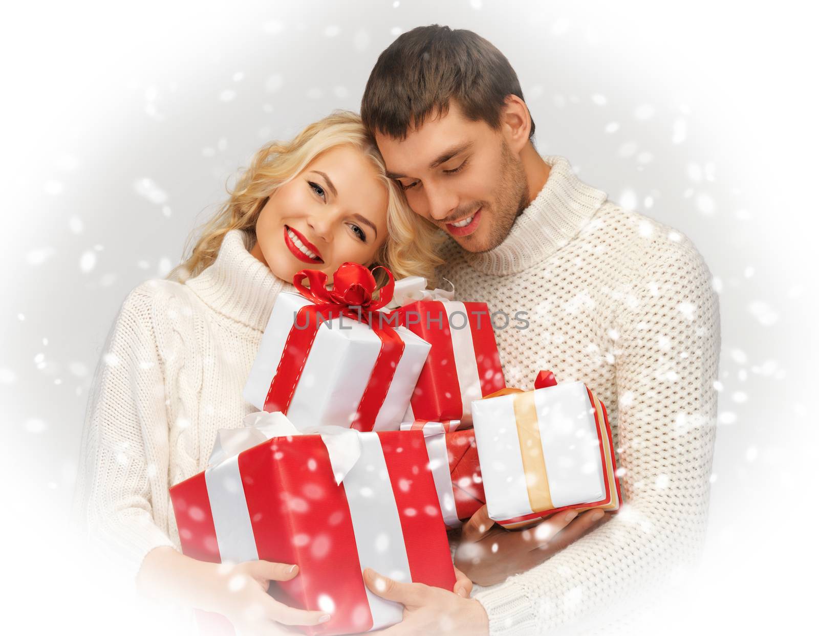 picture of romantic couple in a sweaters with gift boxes