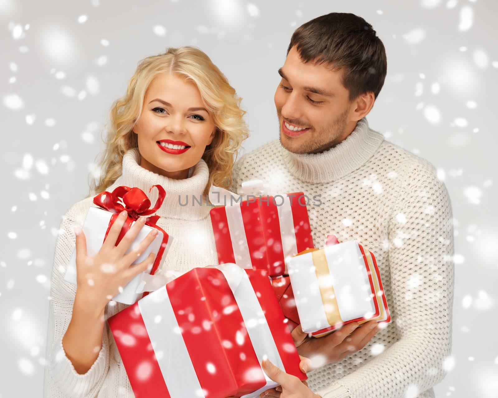 picture of romantic couple in a sweaters with gift boxes