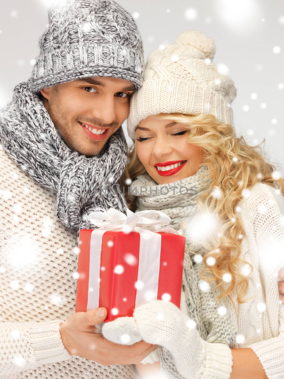 romantic couple in a sweaters with gift box by dolgachov