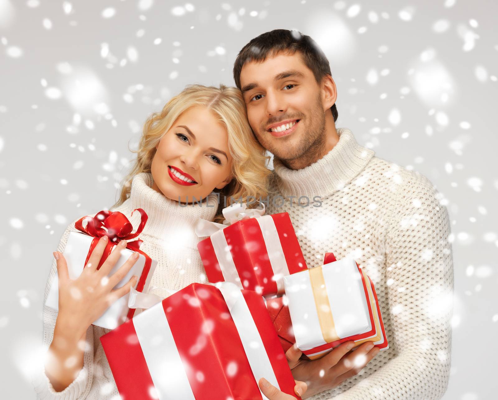 romantic couple in a sweaters with gift boxes by dolgachov