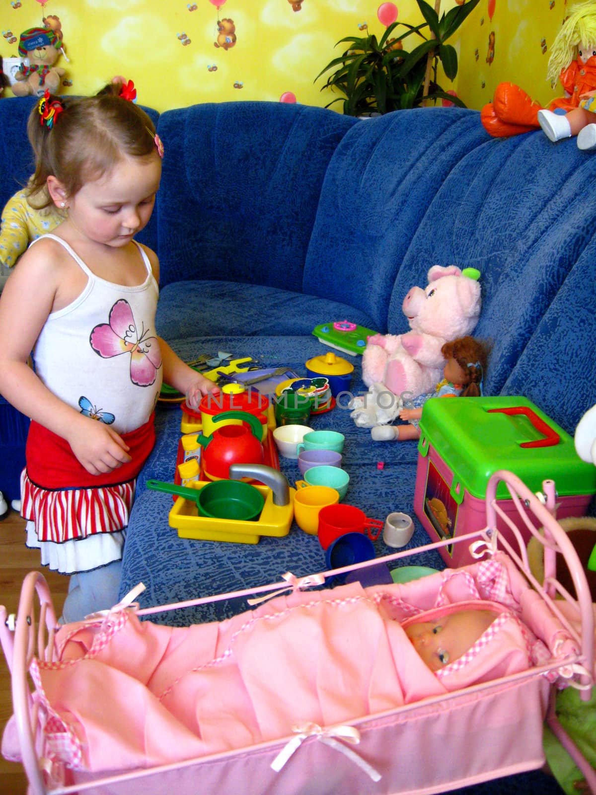 little girl playing with toys and cat in her room