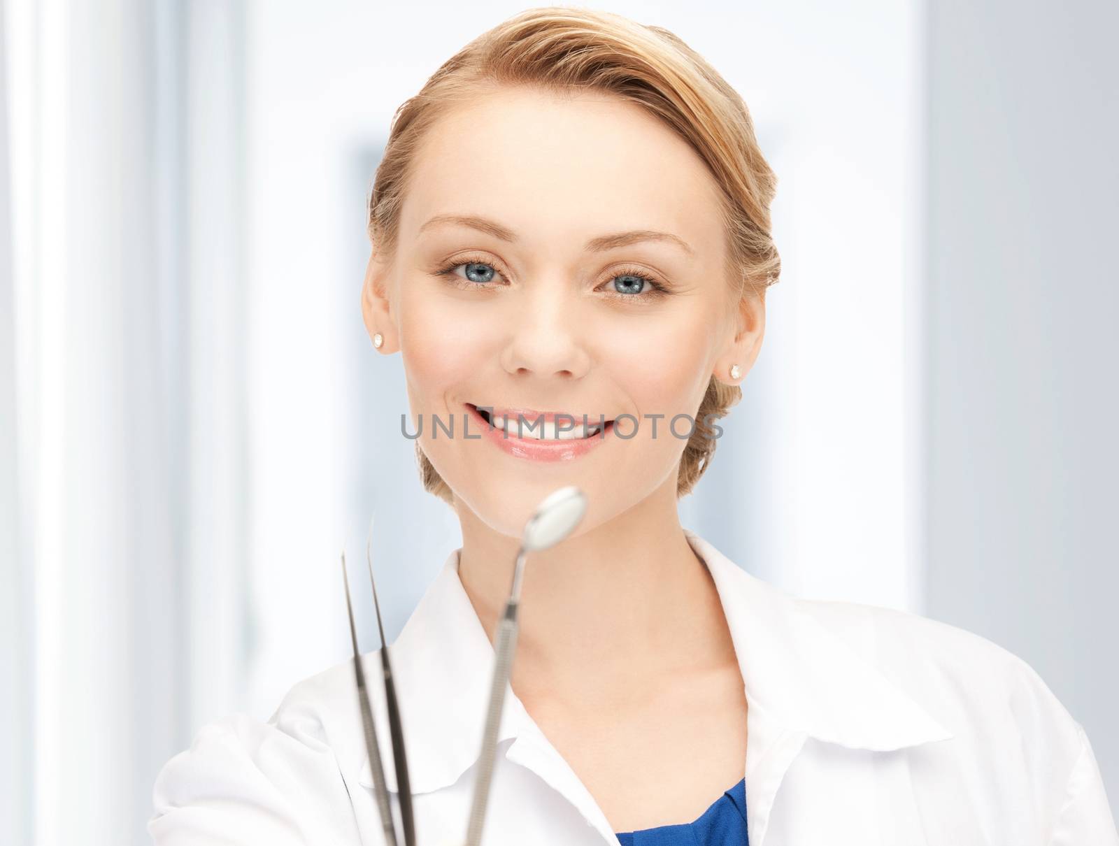 attractive female dentist with tools by dolgachov