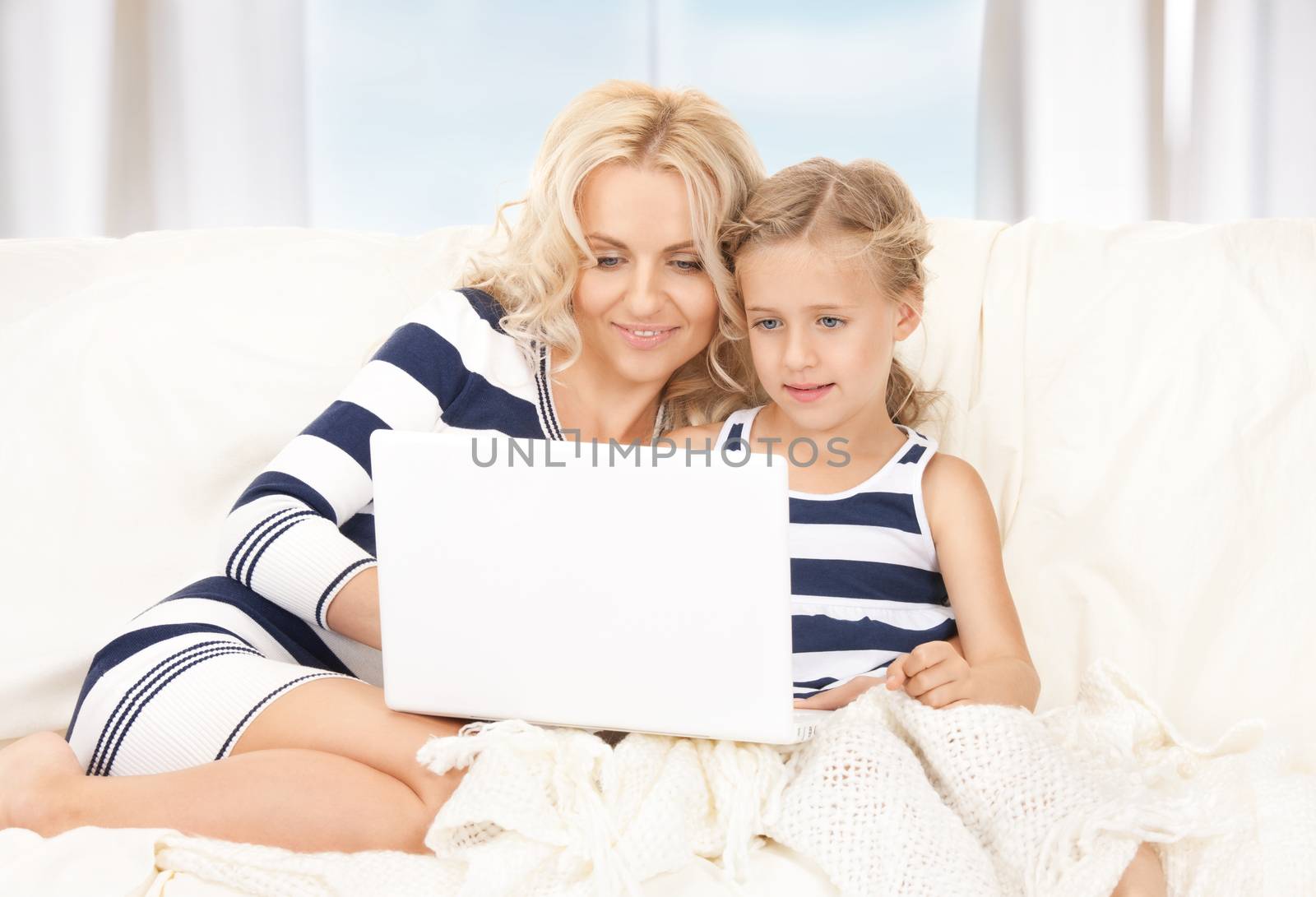 happy mother and child with laptop computer by dolgachov