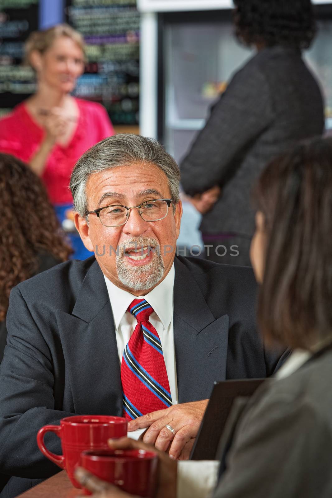 Business man with beard and glasses talking to coworker
