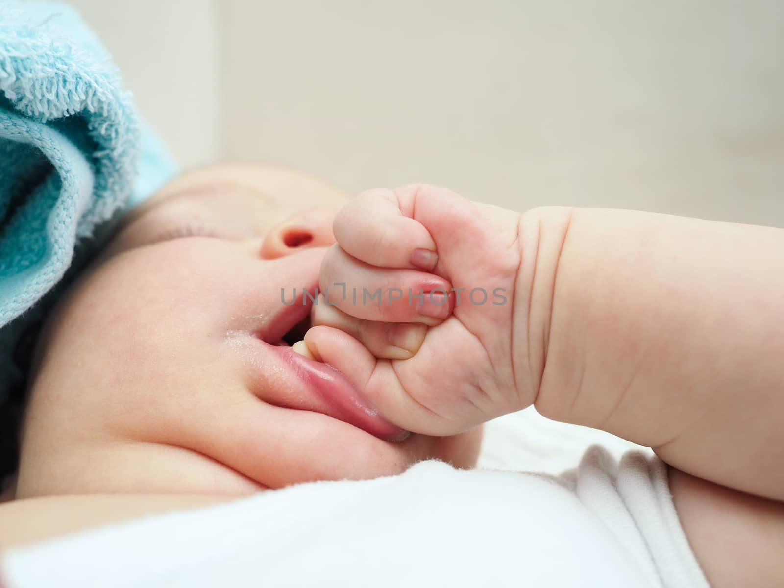 Baby chewing on hand by Arvebettum