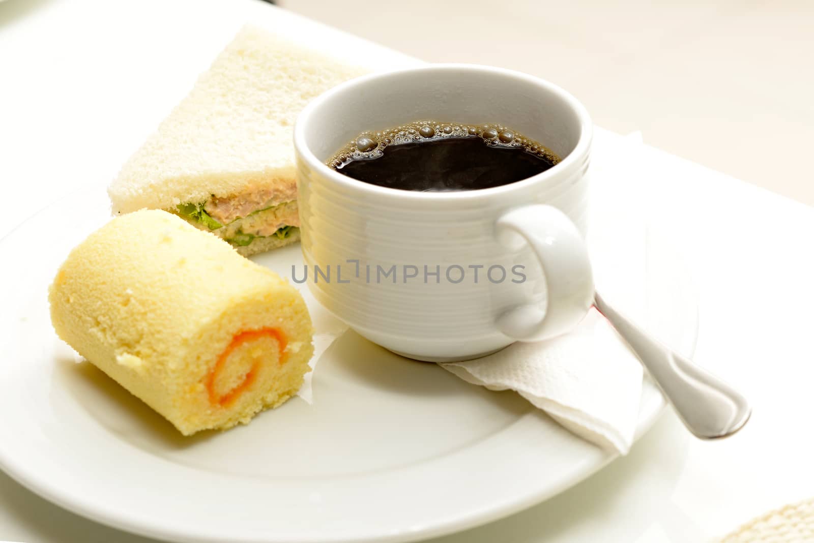 Hot coffee in white cup with sanwich ham&cheese and sweetmeat