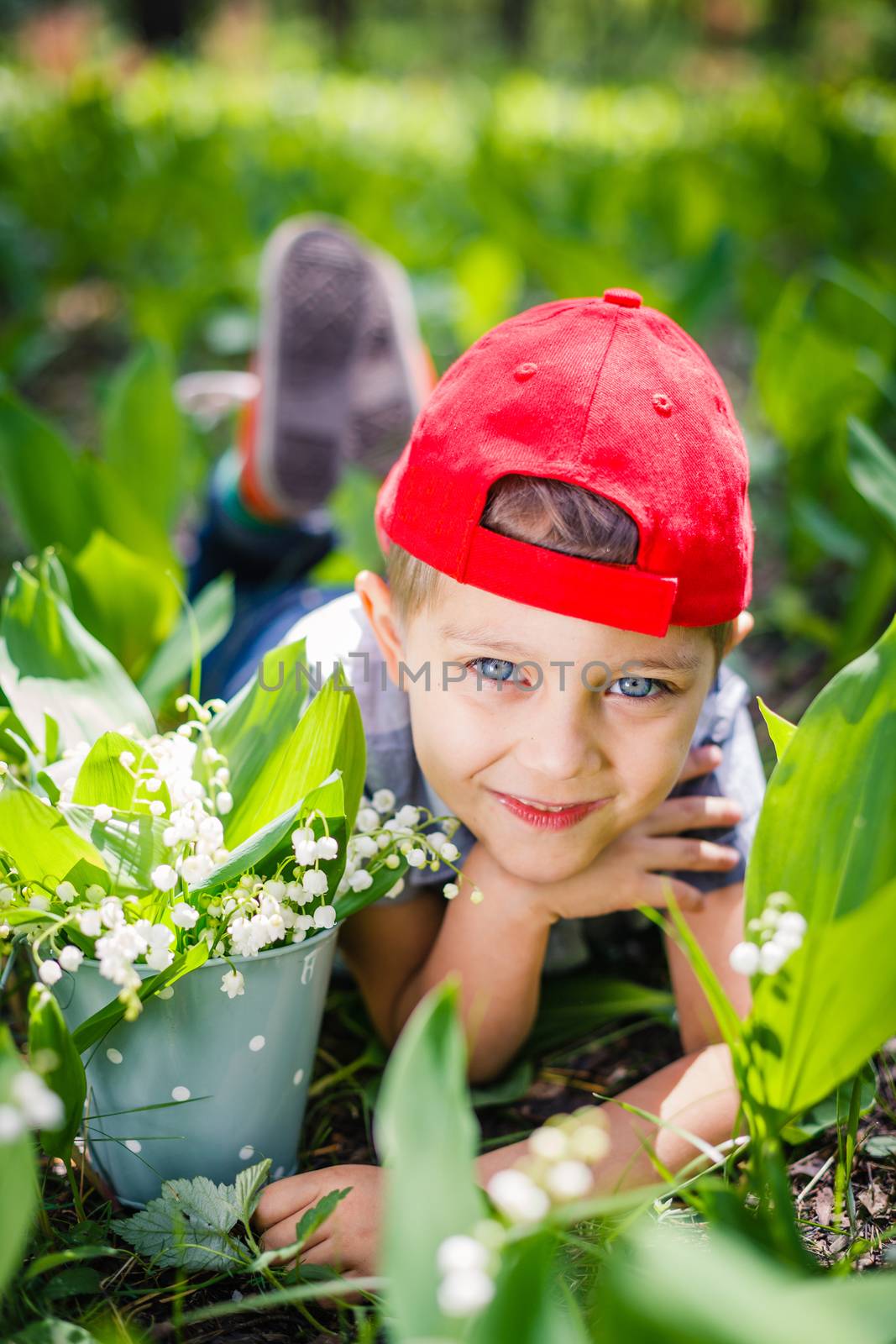 Spring in the forest. A cute boy with lilies of the valley