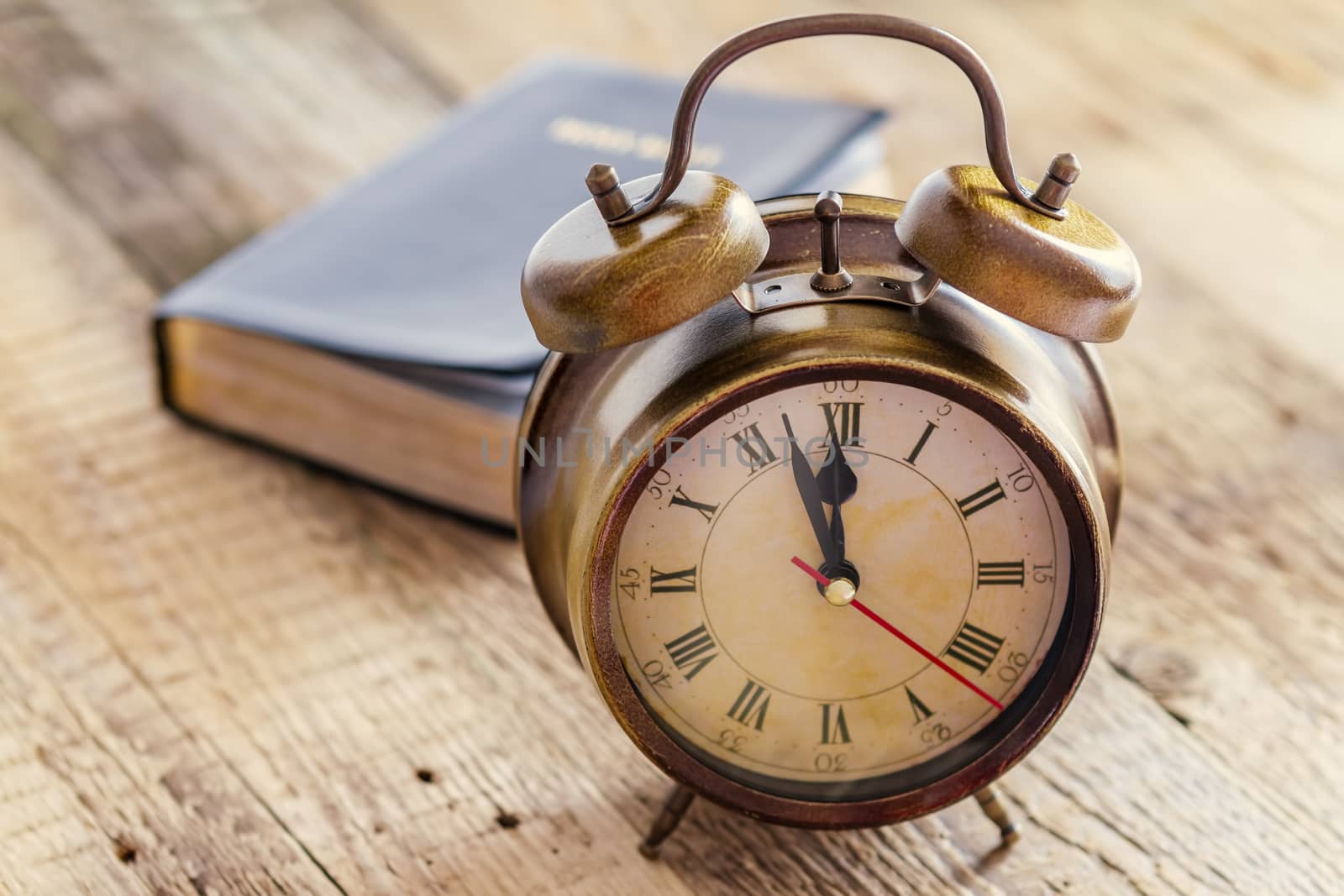 Clock and Bible on wood by manaemedia