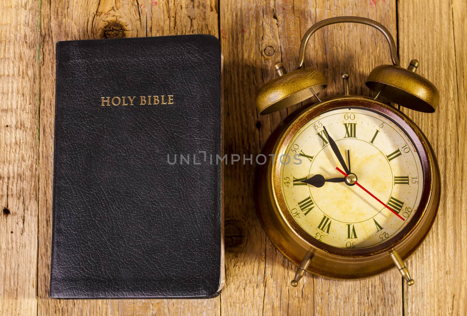 Bible with clock on wood by manaemedia