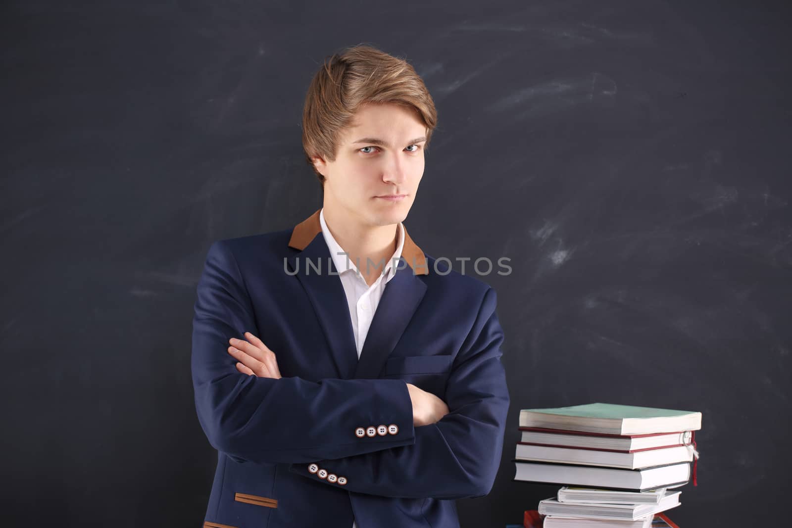 Young, handsome man of success on black chalkboard background