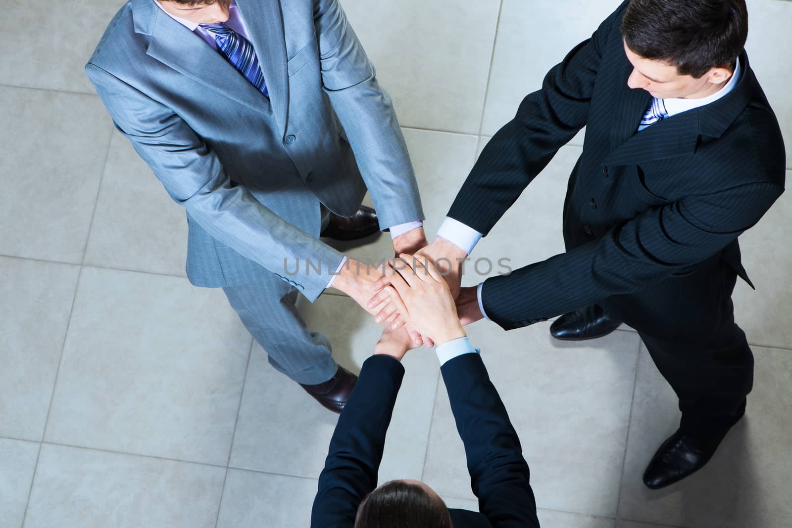 team of three businessmen clasped her hands together, a symbol of teamwork