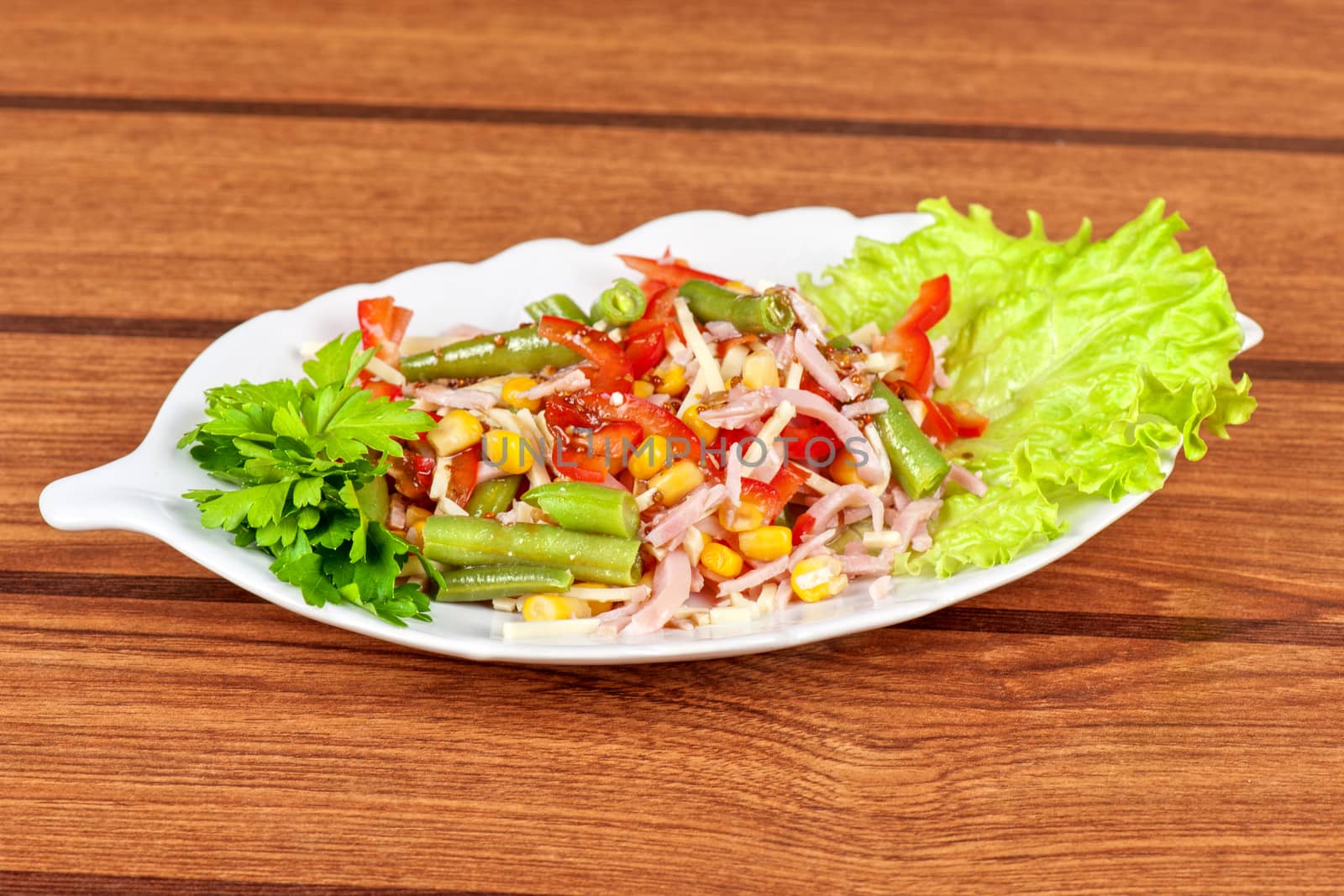 Salad from ham, tomato, green beans, corn and greens