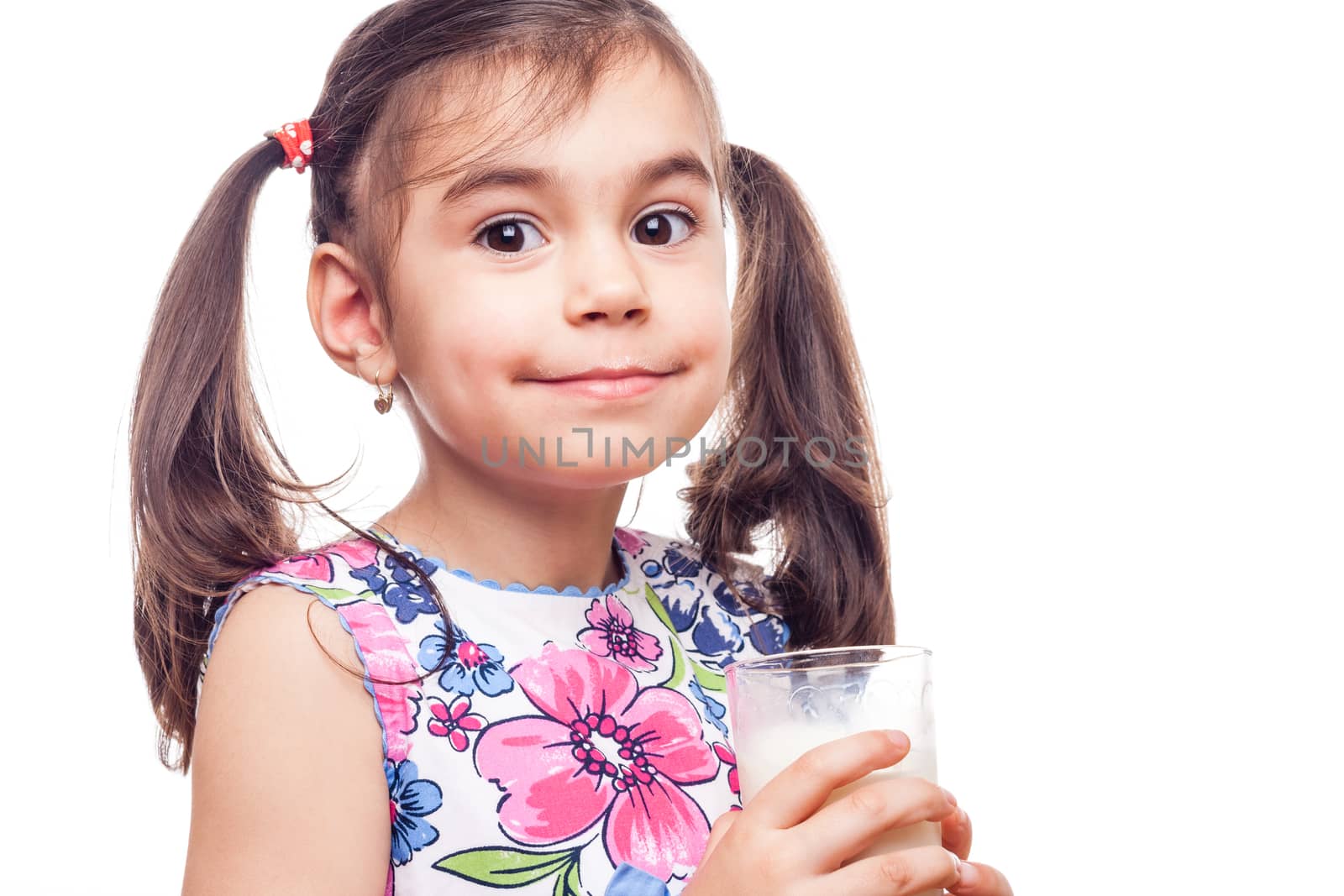 Young girl drinking milk out of glass on white background