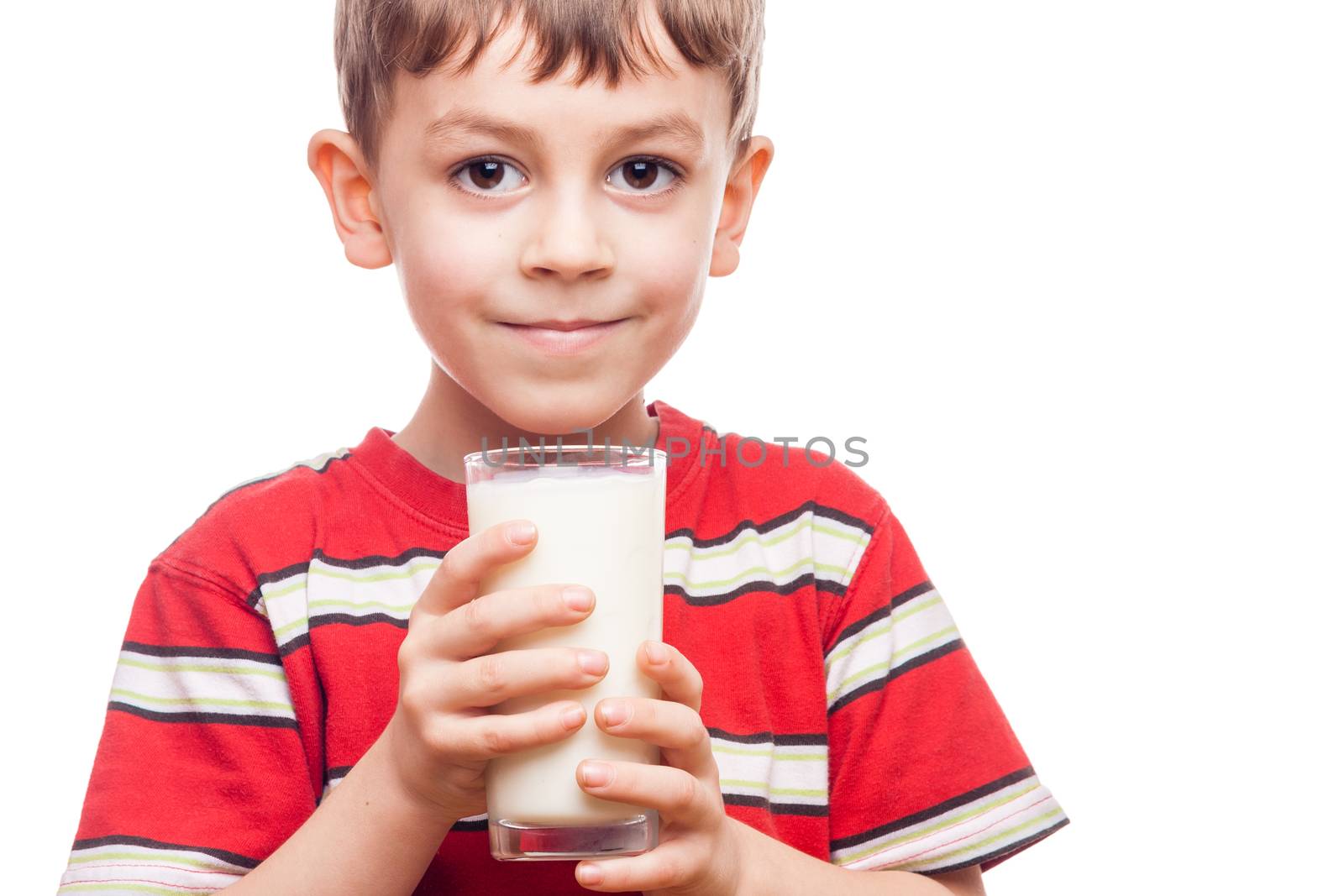Young boy drinking milk out of glass on white background