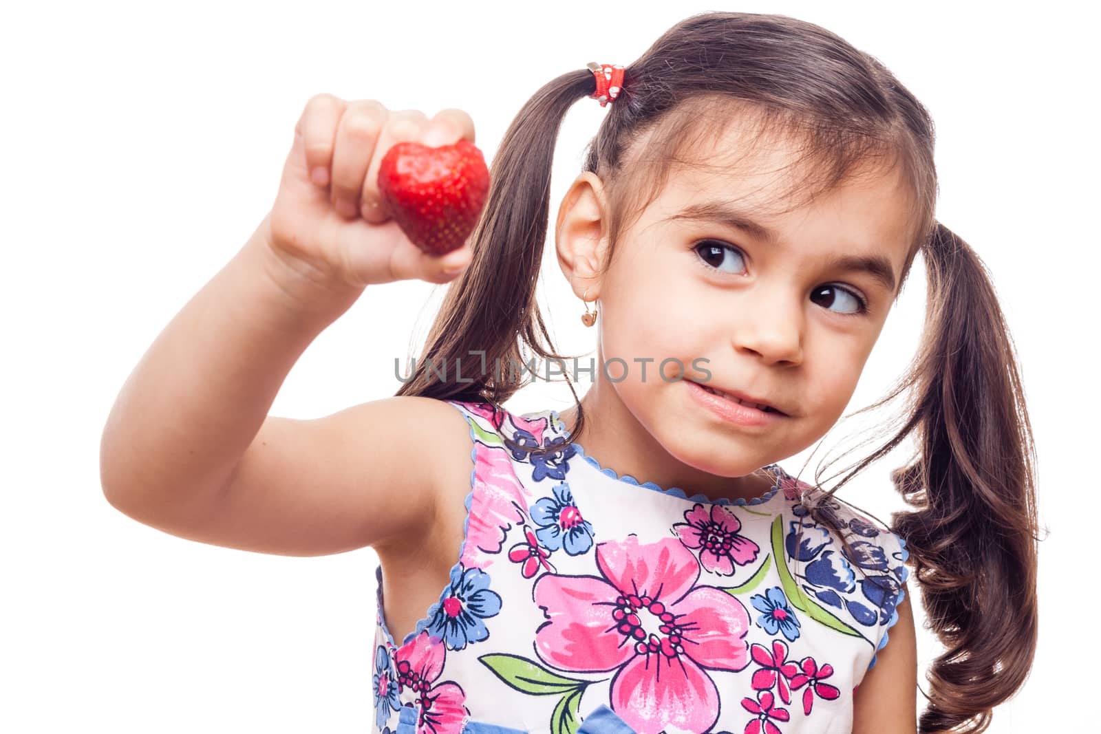 young girl on white background holfing a strawberry