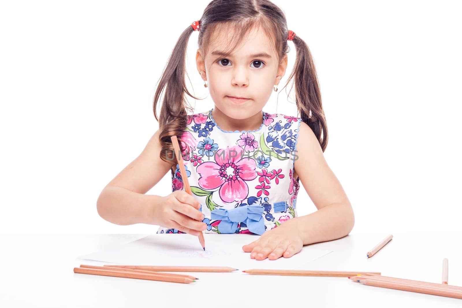 young girl with drawig pencil at white table