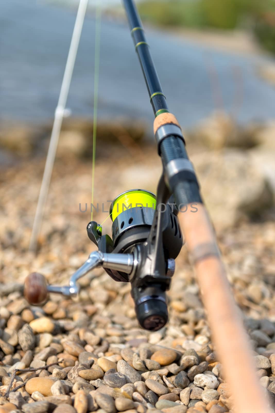 Modern clean fishing rod outdoors on the ground