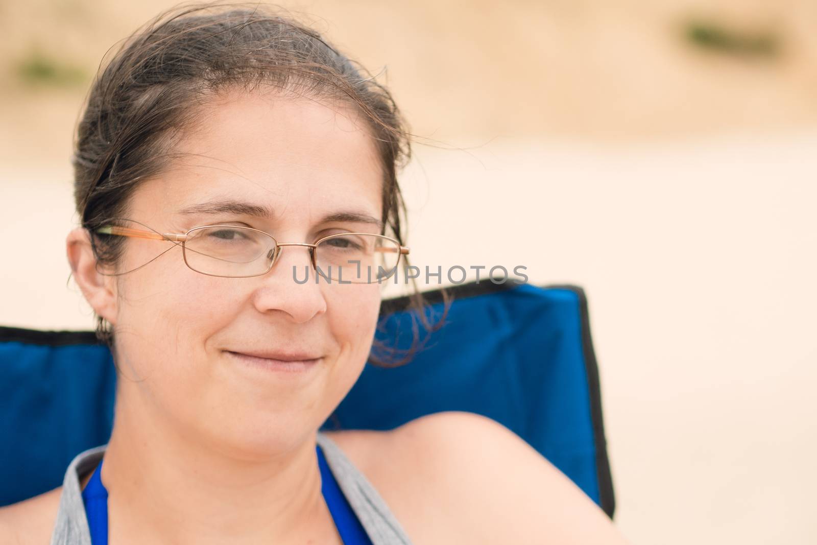 Woman smiling and sitting in a chair on the beach