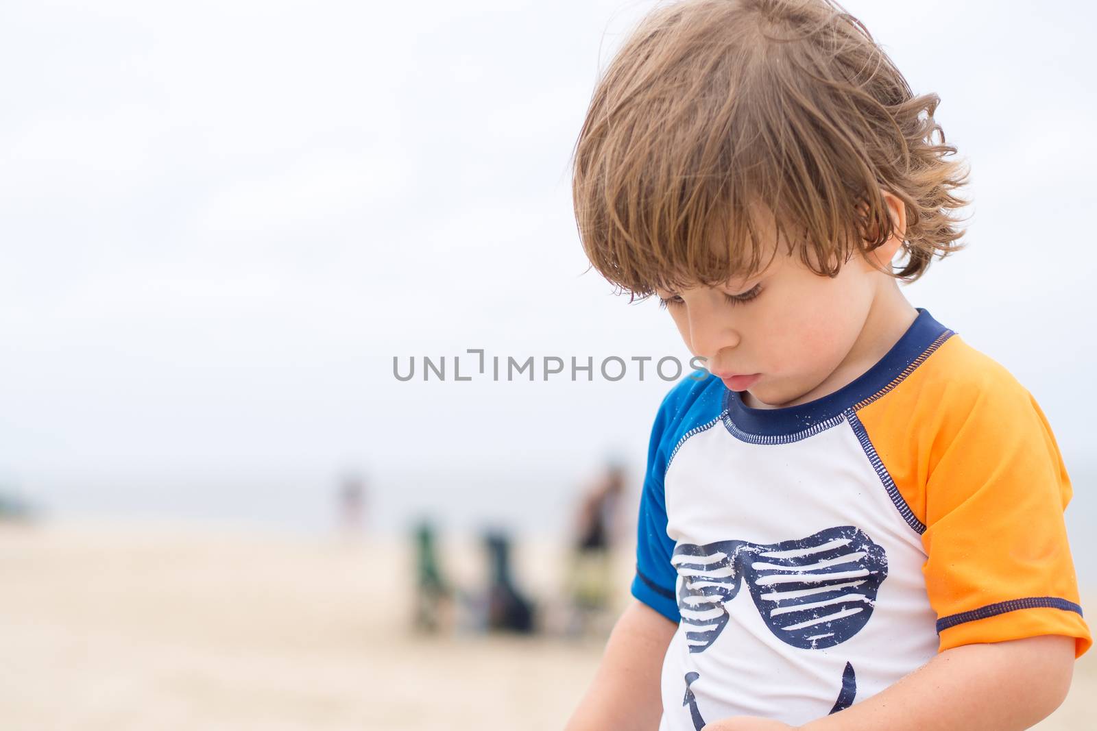Boy playing on the beach by Talanis