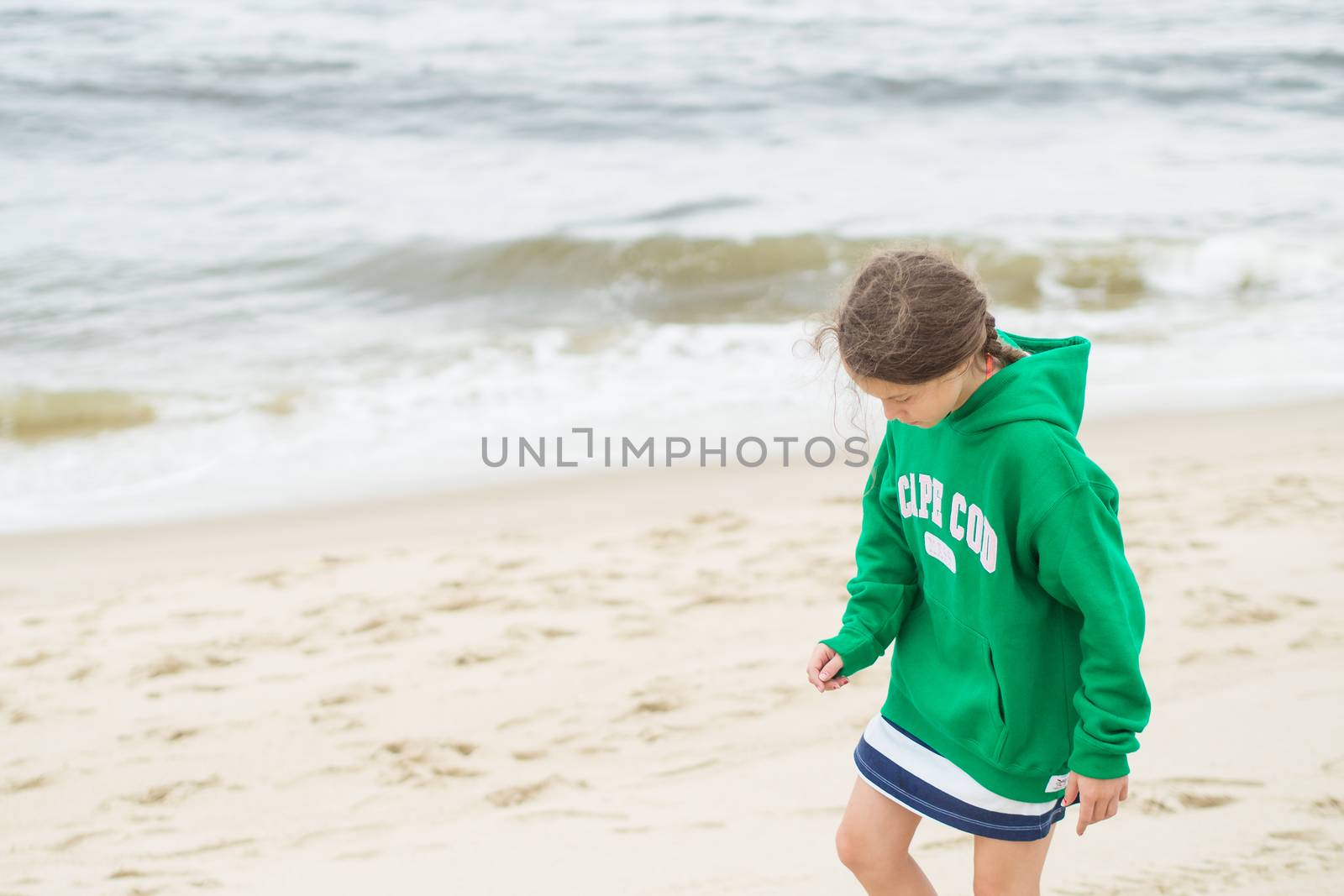 Young girl walking on the beach in Cape Cod on a hazy day