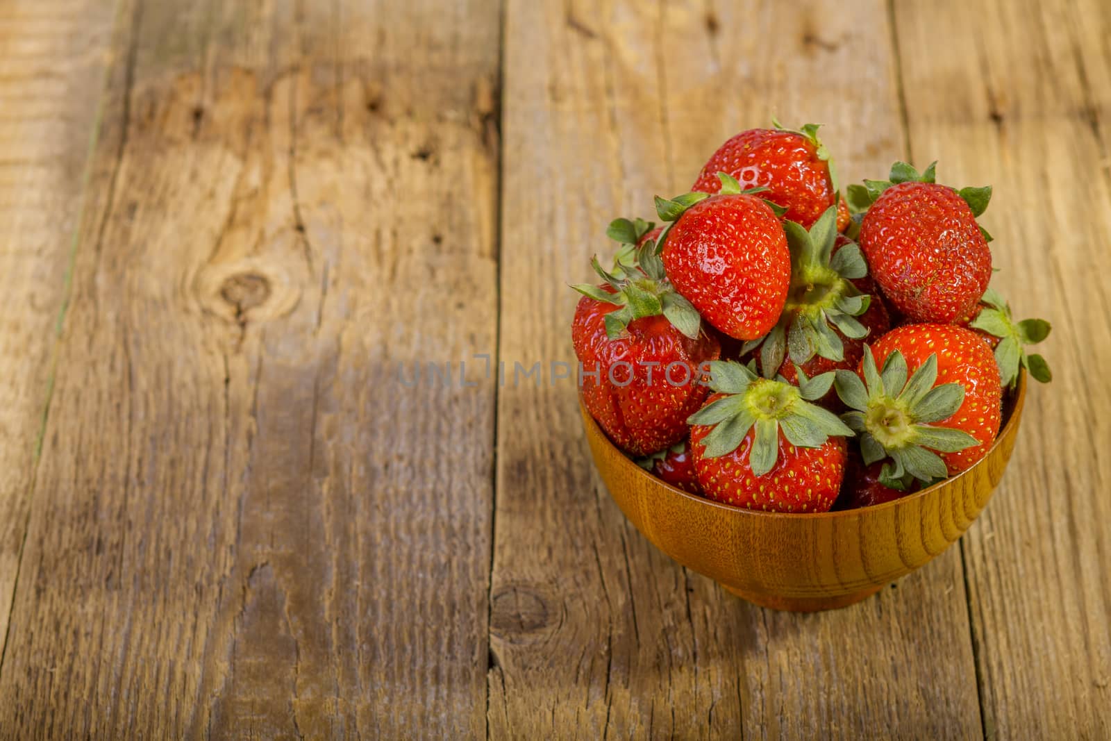 fresh strawberries in wood bowl  by manaemedia