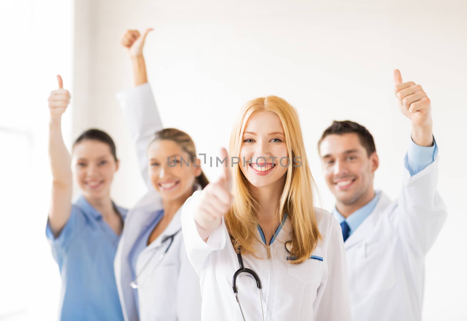 group of doctors showing thumbs up by dolgachov