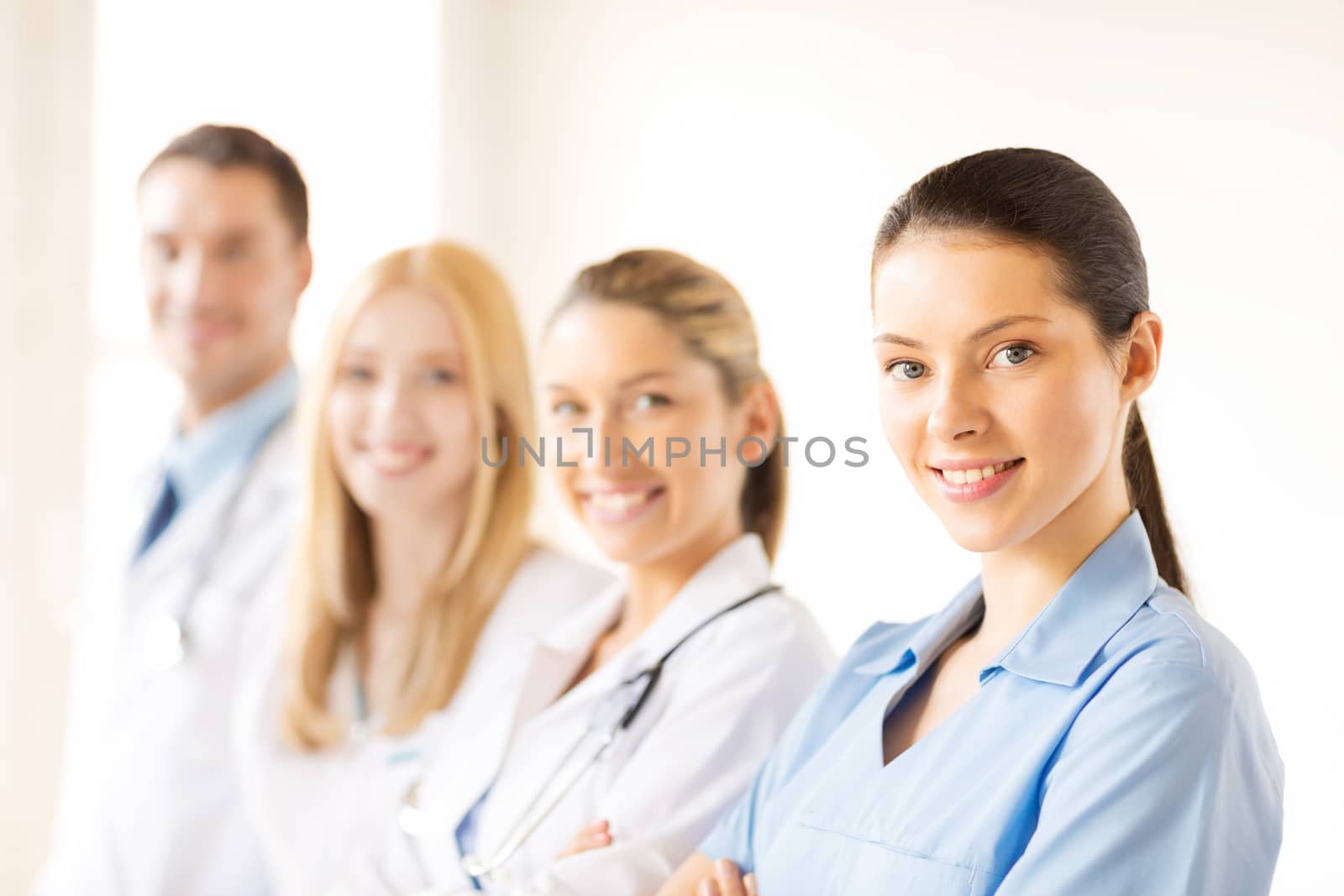 attractive female doctor or nurse in front of medical group