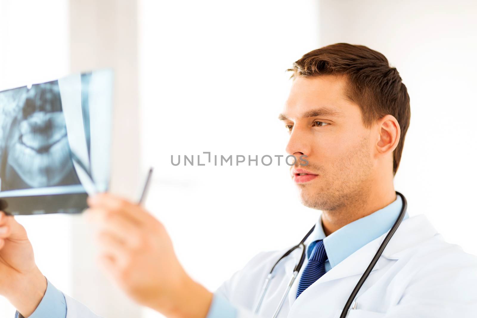 male doctor or dentist looking at x-ray by dolgachov