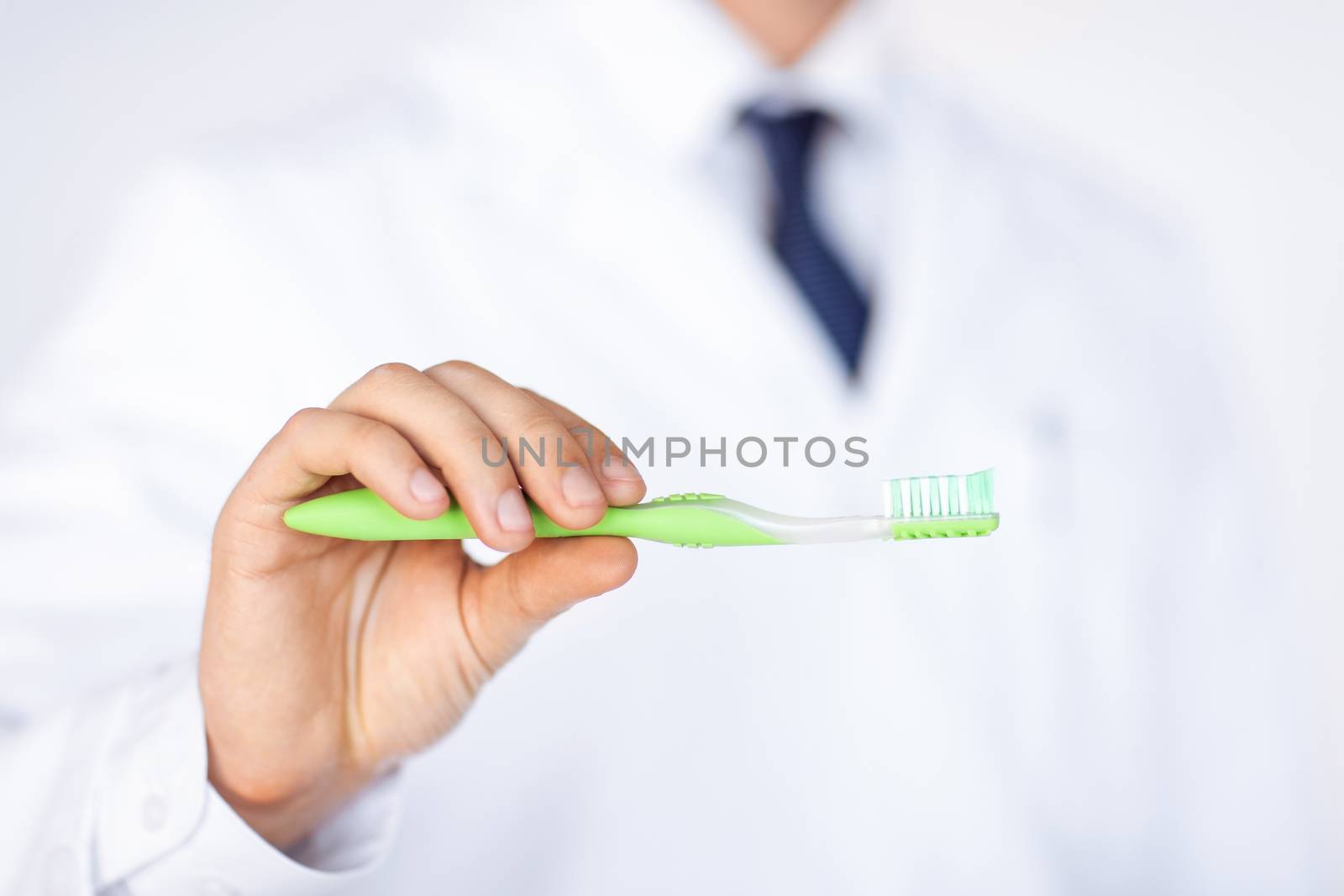 dentist or stomatologist holding toothbrush by dolgachov