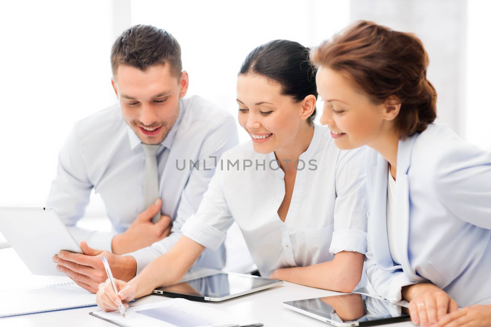friendly business team with tablet pcs having discussion in office