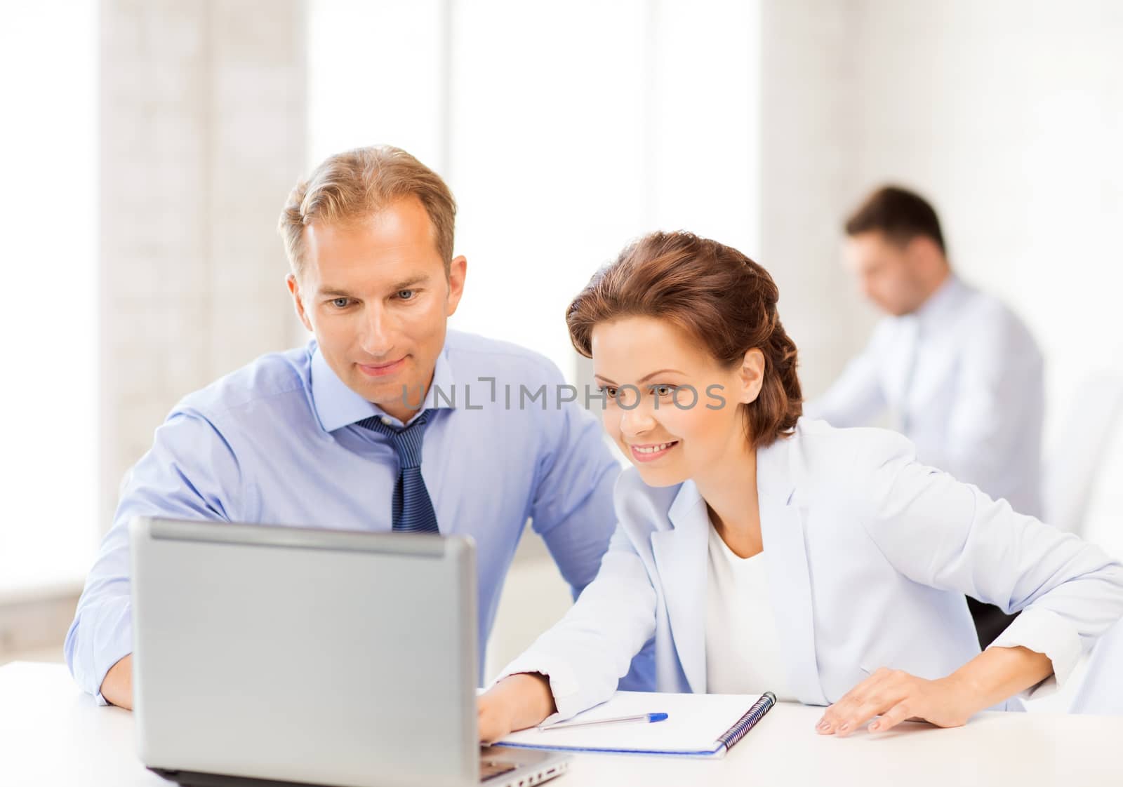 man and woman working with laptop in office by dolgachov