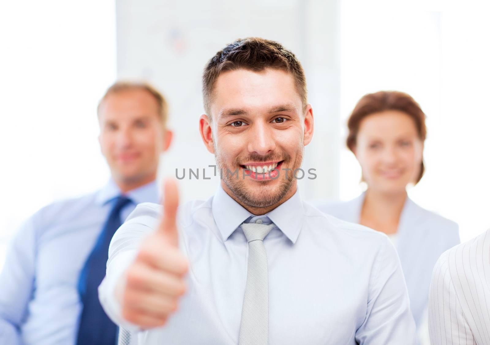 businessman in office showign thumbs up by dolgachov