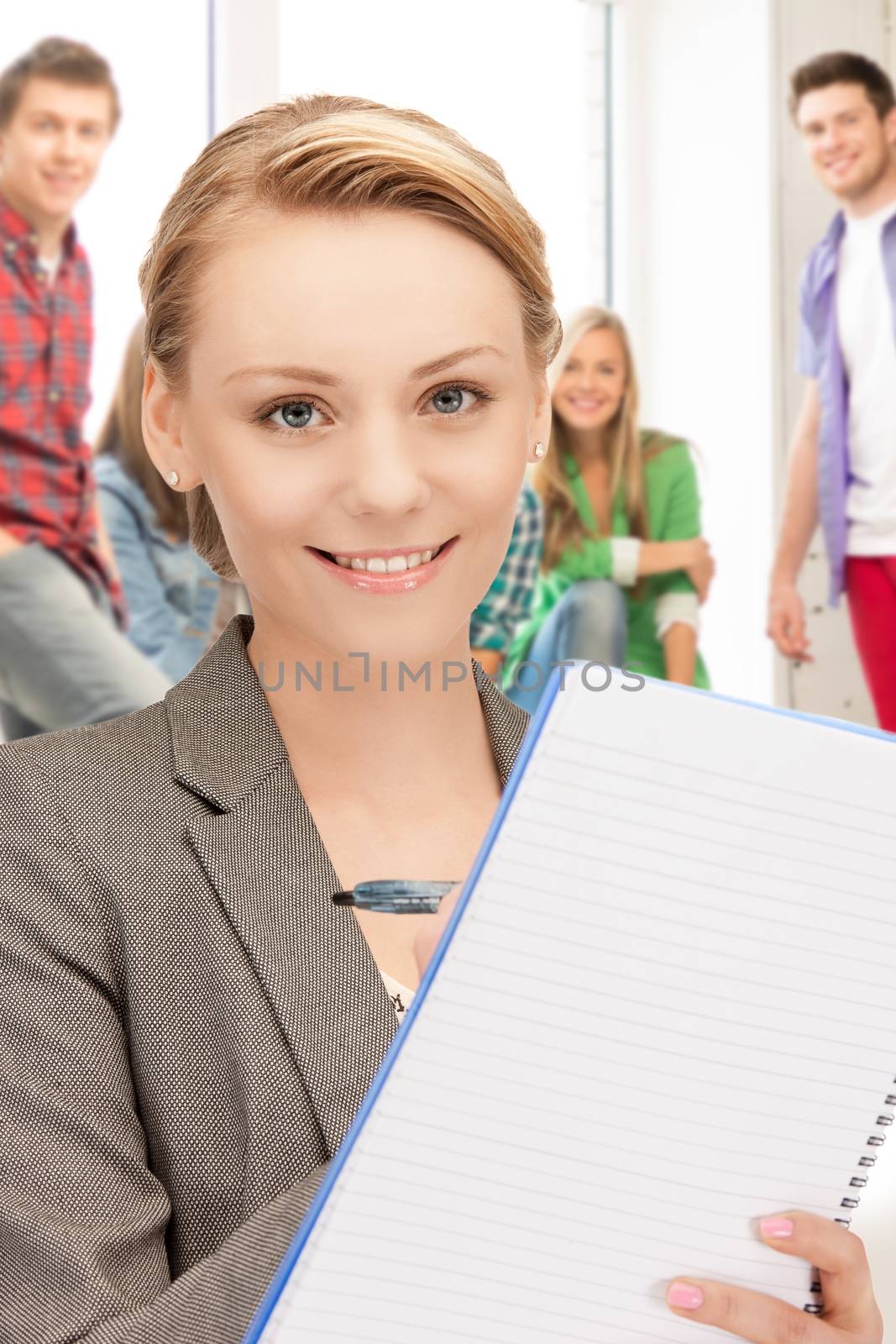 picture of smiling teacher with big notepad at school