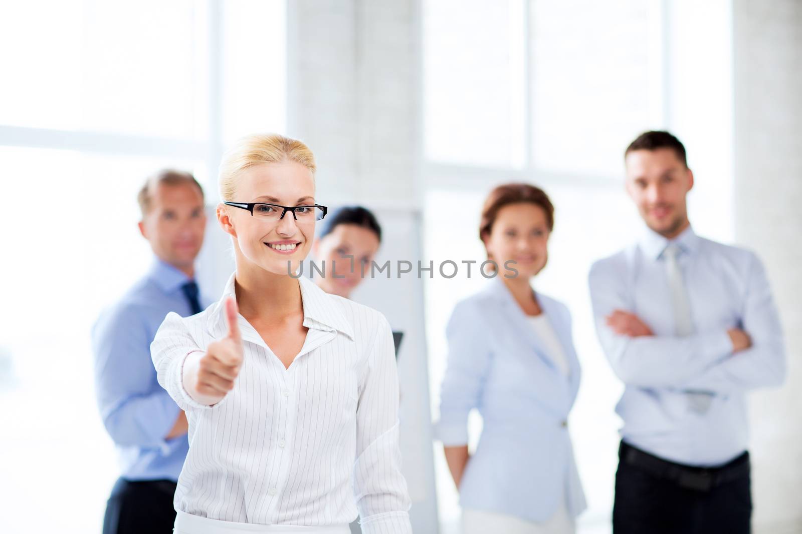 businesswoman in office showign thumbs up by dolgachov