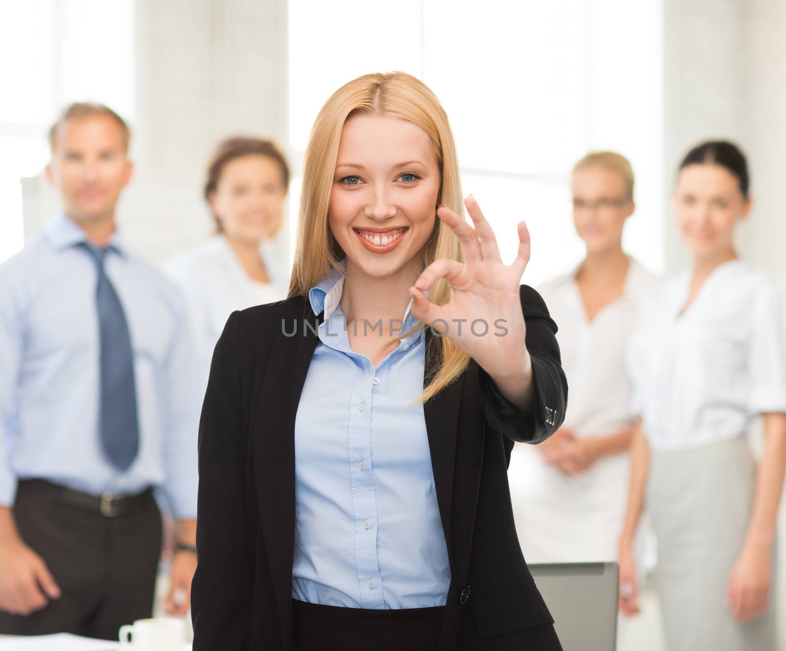 young businesswoman showing ok sign by dolgachov
