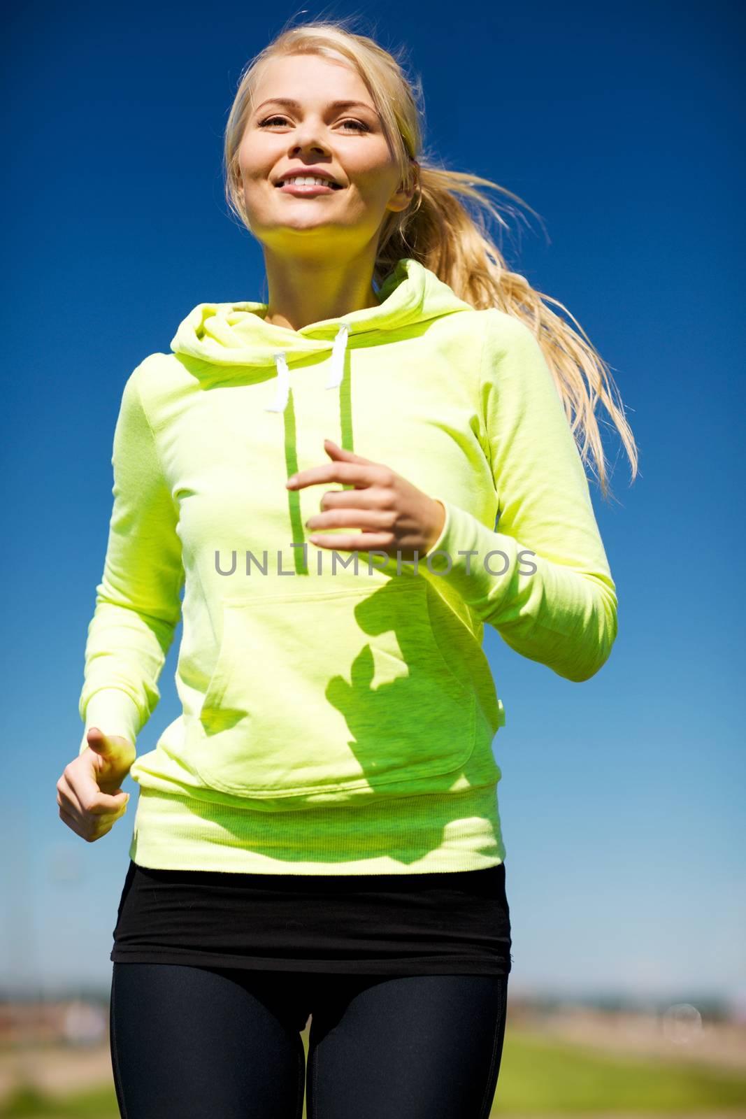 fitness and lifestyle concept - female runner jogging outdoors